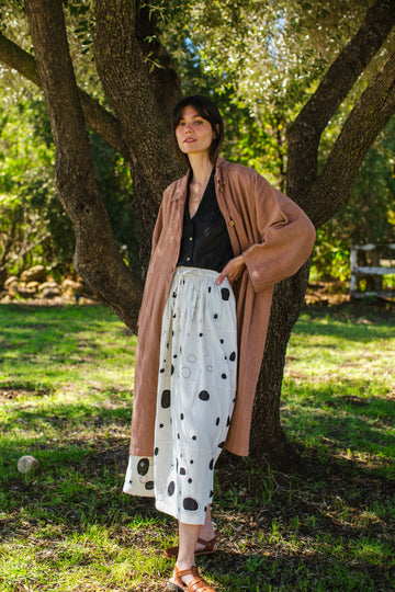 This Raindrops skirt is meticulously crafted from hand-woven fabric. Its exquisite appliqué work adds a touch of enchantment, elevating any ensemble. With its timeless black and white palette, this skirt effortlessly complements a variety of tops and shirts, ensuring versatility and sophistication with every wear.