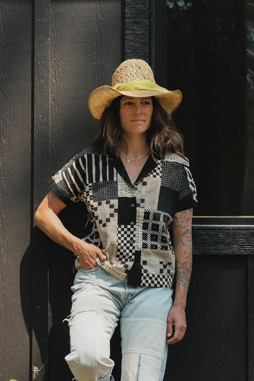 Black and tan hand block-printed patchwork top with short sleeves and solid black cuffs. Features a front placket opening with buttons and is fully lined for added comfort. Crafted from lightweight, non-stretchy cotton that feels soft and breathable on the skin. Ethically made using traditional techniques, with each piece being one-of-a-kind due to slight variations in color and pattern. Falls 22” from the shoulder and fits true to size—perfect for everyday wear with an artisanal, modern touch.