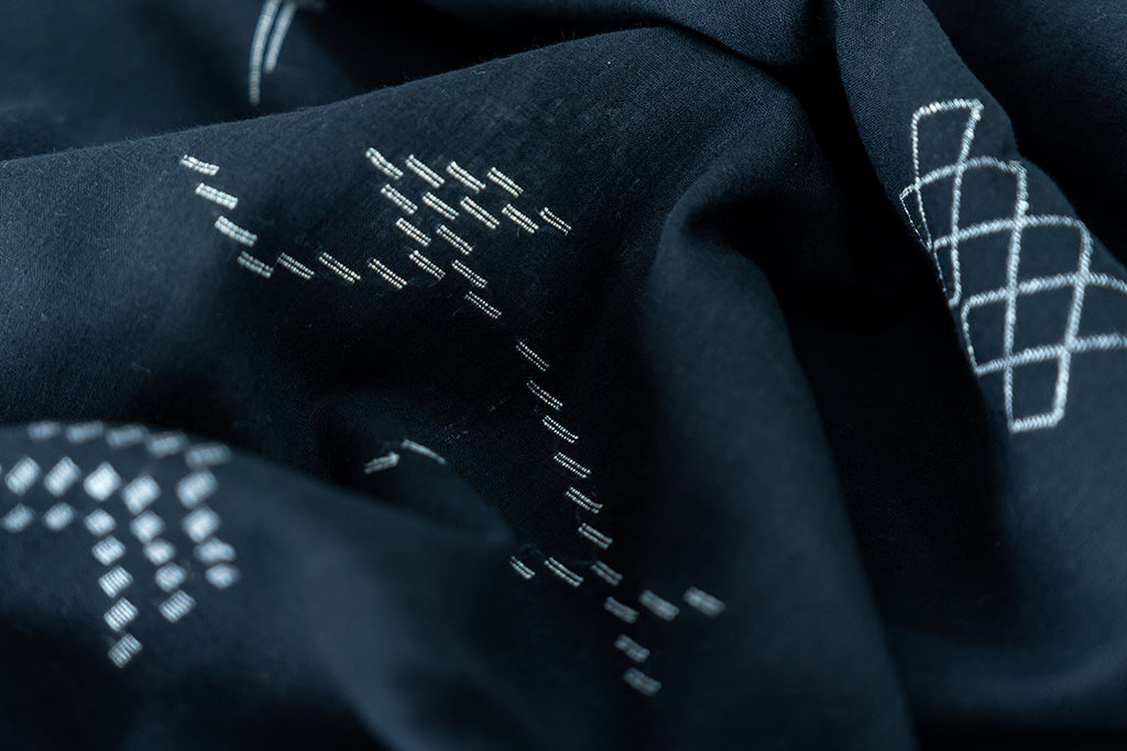 The detailed view of the dress - we can see the honeycomb like patterns hand-stitched into the dress.