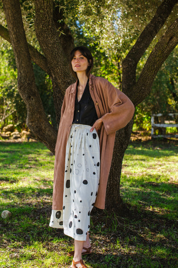 Introducing the Brown Duster jacket, a versatile essential crafted from organic cotton. Designed with a sleek straight collar and adorned with charming coconut buttons, this jacket exudes charm & sophistication. With its straight hem and relaxed fit, it offers both comfort and effortless elegance for any occasion.