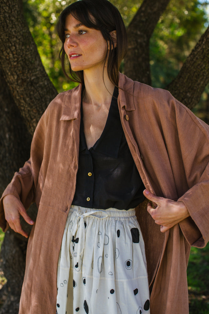 Introducing the Brown Duster jacket, a versatile essential crafted from organic cotton. Designed with a sleek straight collar and adorned with charming coconut buttons, this jacket exudes charm & sophistication. With its straight hem and relaxed fit, it offers both comfort and effortless elegance for any occasion.
