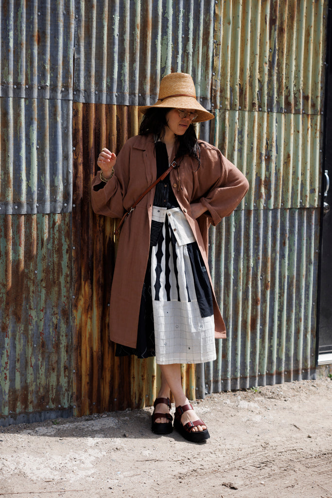 Introducing the Brown Duster jacket, a versatile essential crafted from organic cotton. Designed with a sleek straight collar and adorned with charming coconut buttons, this jacket exudes charm & sophistication. With its straight hem and relaxed fit, it offers both comfort and effortless elegance for any occasion.