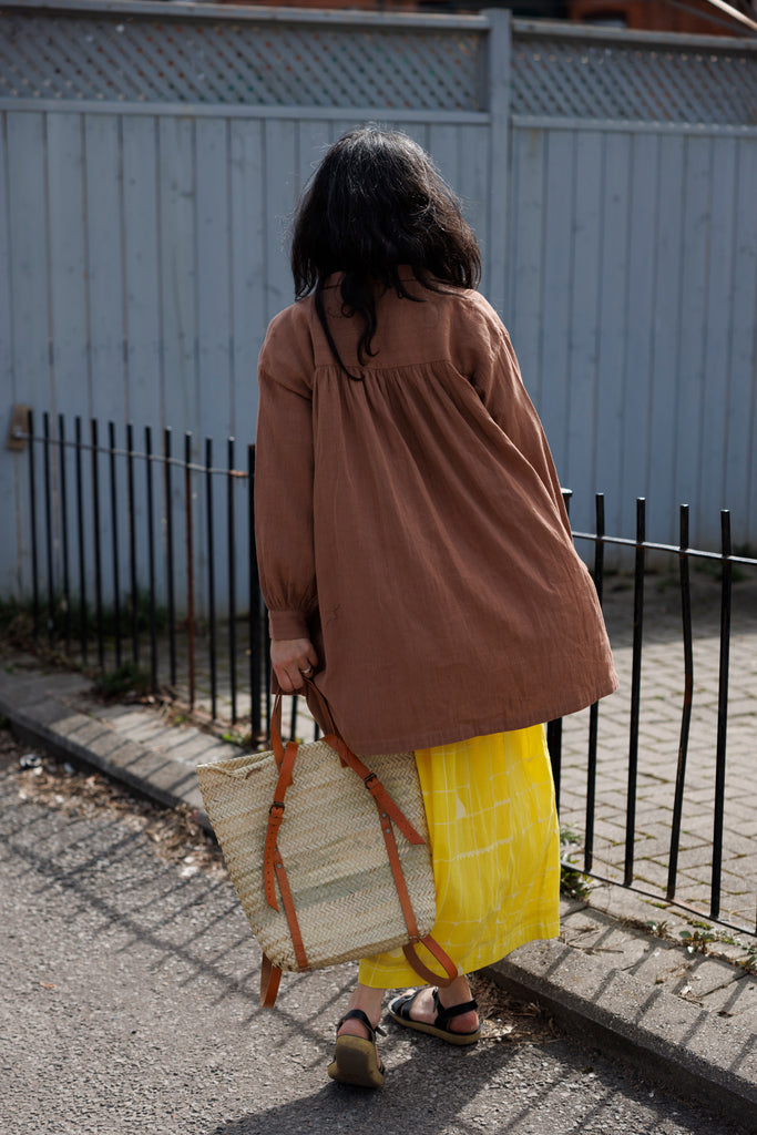 Indulge in the timeless appeal of this artist smock, tailored for both artists and creatives, as well as individuals seeking a stylish layer for their ensemble. The rich rusty brown hue adds a distinctive touch, seamlessly complementing any outfit for an elevated look. Featuring full sleeves, button closure, and a convenient front pocket, this smock offers both practicality and sophistication in one.