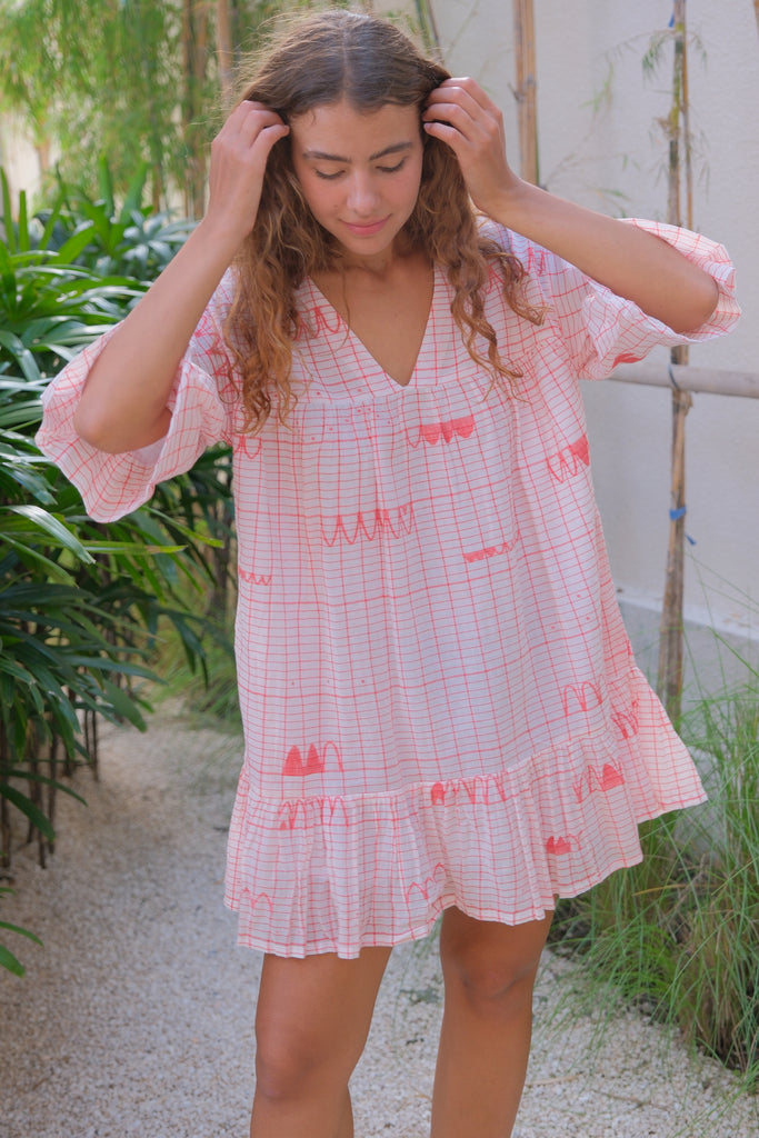 Introducing our Cuban Dress, crafted in collaboration between Audrey E Leary and World of Crow. This mini dress in vibrant red features a V-neck and is made from soft, breathable jamdani fabric. Sustainably produced from handwoven cotton, it combines comfort with stylish red motifs, perfect for everyday wear